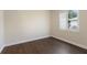 Bright bedroom with wood floors and natural light from the window with white shutters at 4998 Cedar Oak Way, Sarasota, FL 34233
