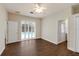 A bright bedroom with a ceiling fan, hardwood floors, and doors opening to the pool at 4998 Cedar Oak Way, Sarasota, FL 34233