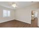 A bright bedroom with wood floors, a ceiling fan, and natural light from the window at 4998 Cedar Oak Way, Sarasota, FL 34233