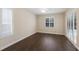 Bedroom featuring wood-look laminate flooring, plantation shutters, and neutral paint at 4998 Cedar Oak Way, Sarasota, FL 34233