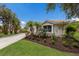 Lush front yard with palm trees and mature plants leading to the charming home at 4998 Cedar Oak Way, Sarasota, FL 34233