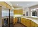 Kitchen with stainless steel appliances, wood cabinetry, and view to the pool area at 4998 Cedar Oak Way, Sarasota, FL 34233