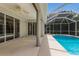 View of screened pool enclosure with ceiling fan, backyard, and sliding glass doors at 4998 Cedar Oak Way, Sarasota, FL 34233