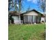 Back exterior featuring a screened porch and well-maintained yard, creating a serene setting at 5213 20Th Street E Ct, Bradenton, FL 34203