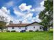 Exterior view of house with an expansive, well-manicured lawn under a blue sky at 5213 20Th Street E Ct, Bradenton, FL 34203