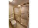Bathroom featuring a toilet, shower with glass doors, and tiled floors at 5213 20Th Street E Ct, Bradenton, FL 34203