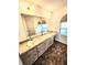 Spacious bathroom featuring double sinks, vanity with marble countertop and an arched window at 5213 20Th Street E Ct, Bradenton, FL 34203