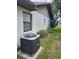 Exterior of the home with a well-maintained AC unit, landscaping, and window at 5213 20Th Street E Ct, Bradenton, FL 34203