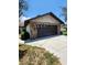 Oversized garage featuring a stone facade and a concrete driveway, perfect for multiple vehicles at 5213 20Th Street E Ct, Bradenton, FL 34203