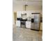 Modern kitchen with stainless steel appliances, white cabinets, and gray countertops at 5213 20Th Street E Ct, Bradenton, FL 34203