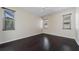 Bright bedroom with dark hardwood floors, three windows and a ceiling fan at 5410 Matthew Ct, Sarasota, FL 34231