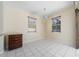 Dining room featuring tile floors, dark wood dresser, chandelier and two windows at 5410 Matthew Ct, Sarasota, FL 34231