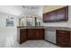 Kitchen boasts granite countertops, stainless steel dishwasher and dark wood cabinets at 5410 Matthew Ct, Sarasota, FL 34231
