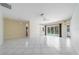 Open living space with white tile floors, neutral walls, and sliding glass doors at 5410 Matthew Ct, Sarasota, FL 34231