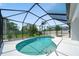 Screened-in pool area with tropical landscaping and clear blue water at 5410 Matthew Ct, Sarasota, FL 34231