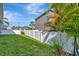 A spacious, green back yard with a white picket fence surrounding the area with several palm trees planted inside at 5515 69Th E Pl, Ellenton, FL 34222