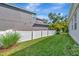Spacious backyard featuring well-maintained lawn, complemented by a modern gray home exterior and white picket fence at 5515 69Th E Pl, Ellenton, FL 34222