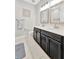 Elegant bathroom featuring double vanity sinks, modern mirrors, and tile flooring for a spa-like experience at 5515 69Th E Pl, Ellenton, FL 34222
