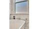 Close up of a modern soaking tub with marble tile walls, chrome fixtures, and a window view at 5515 69Th E Pl, Ellenton, FL 34222