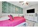 Bright bedroom with an accent wall, ceiling fan, and a comfortable bed dressed in inviting pink linens at 5515 69Th E Pl, Ellenton, FL 34222