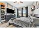 Spacious bedroom with a dark ceiling fan, dark accents, and wall-mounted TV at 5515 69Th E Pl, Ellenton, FL 34222