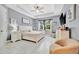 A primary bedroom showcases a tray ceiling, tiled floors, and neutral colored furniture at 5515 69Th E Pl, Ellenton, FL 34222