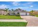 Charming single-story home boasts a well-manicured lawn, brick driveway, and a three-car garage at 5515 69Th E Pl, Ellenton, FL 34222