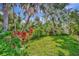 Lush tropical landscaping in the backyard creates a serene and private outdoor environment with mature trees at 5515 69Th E Pl, Ellenton, FL 34222