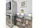 Modern laundry area featuring stacked washer/dryer, complemented by stylish shelving and decorative accents at 5515 69Th E Pl, Ellenton, FL 34222