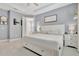 Bright main bedroom with white furniture, tile floors, and attached bathroom with a soaking tub at 5515 69Th E Pl, Ellenton, FL 34222