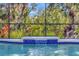 A closer view of the swimming pool's waterfall feature, enhanced with decorative blue tile under a screen enclosure at 5515 69Th E Pl, Ellenton, FL 34222