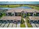 Stunning aerial view of condo building with golf course and water views, featuring lush landscaping and private garages at 5604 Palmer Cir # 103, Bradenton, FL 34211