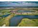 Expansive aerial view of lakeside condo community nestled amidst picturesque golf courses and tranquil waterways at 5604 Palmer Cir # 103, Bradenton, FL 34211