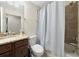 Well-lit bathroom with granite counters, framed mirror, tub-shower with gingham curtain, & fixtures for a clean, functional space at 5604 Palmer Cir # 103, Bradenton, FL 34211
