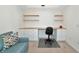 This bedroom boasts a sofa, built-in desk with drawers, and floating shelves for functional style at 5604 Palmer Cir # 103, Bradenton, FL 34211