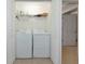 Convenient laundry room features a washer and dryer, with shelves for storage, and a door leading to the next room at 5604 Palmer Cir # 103, Bradenton, FL 34211