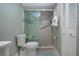 Bathroom featuring tiled shower with glass door, toilet, and linen closet at 5750 Midnight Pass Rd # 203, Sarasota, FL 34242
