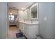 Bathroom with dual sinks, granite counters, mirrors, and access to bedroom at 5750 Midnight Pass Rd # 203, Sarasota, FL 34242