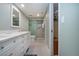 Well-lit bathroom with walk-in glass shower, white vanity, and closet with shelving at 5750 Midnight Pass Rd # 203, Sarasota, FL 34242