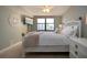 Comfortable bedroom with elegant white furniture, ceiling fan, and sunny window views with attached tv at 5750 Midnight Pass Rd # 203, Sarasota, FL 34242