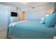 Nicely decorated bedroom with ceiling fan, mounted TV, and adjacent bathroom at 5750 Midnight Pass Rd # 203, Sarasota, FL 34242