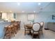 A combined dining area and kitchen featuring a table with seating, white cabinetry, and views of the living space at 5750 Midnight Pass Rd # 203, Sarasota, FL 34242