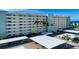 Multi-story condo building featuring covered parking and lush landscaping near the sandy beach at 5750 Midnight Pass Rd # 203, Sarasota, FL 34242