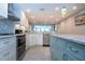 Updated kitchen showcasing white cabinets, stainless steel appliances, gray backsplash, and island with seating at 5750 Midnight Pass Rd # 203, Sarasota, FL 34242