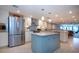 An open-plan kitchen featuring a blue island, modern appliances, and bright lighting throughout the area at 5750 Midnight Pass Rd # 203, Sarasota, FL 34242