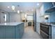 Modern kitchen featuring stainless steel appliances, custom cabinets, and a center island at 5750 Midnight Pass Rd # 203, Sarasota, FL 34242