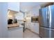 Bright kitchenette featuring granite counters, white cabinets, and modern stainless-steel appliances at 5750 Midnight Pass Rd # 203, Sarasota, FL 34242