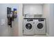 Laundry room featuring front loading washer/dryer and cabinet storage at 5750 Midnight Pass Rd # 203, Sarasota, FL 34242