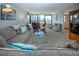 Bright living room features large windows, comfortable seating, and a glass coffee table with views of the outdoors at 5750 Midnight Pass Rd # 203, Sarasota, FL 34242
