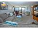 Bright living room features large windows, comfortable seating, and a glass coffee table with views of the outdoors at 5750 Midnight Pass Rd # 203, Sarasota, FL 34242
